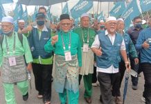 Penyokong PN berarak dalam hujan di Port Dickson