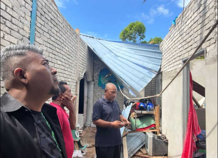 Mustaqim Abdullah meninjau keadaan rumah yang dilanda ribut di Kampung Bakau